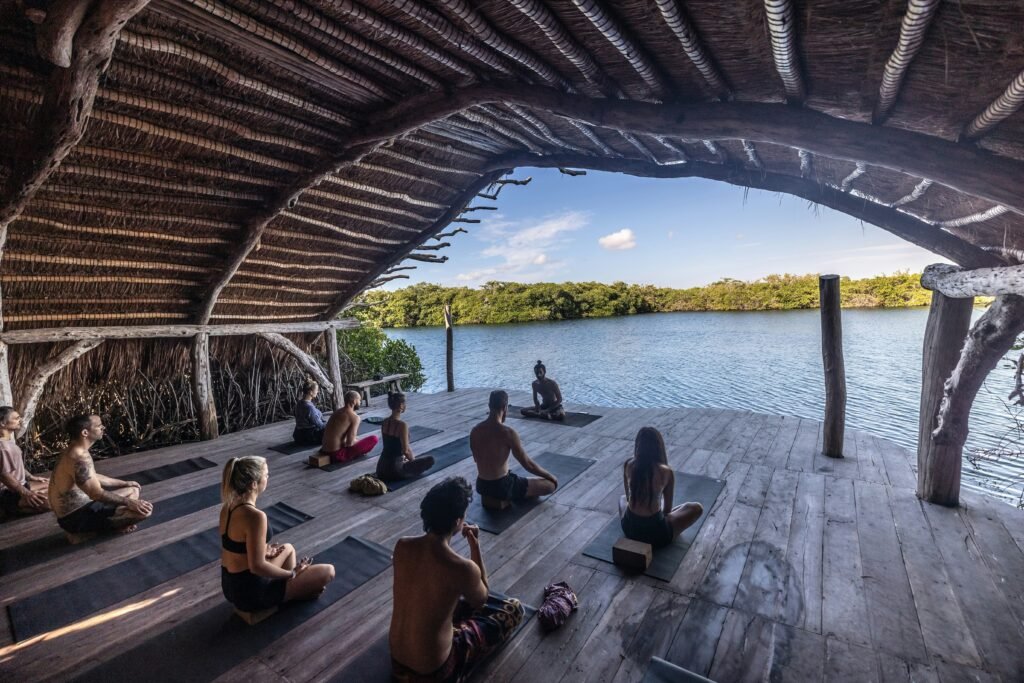 group-of-people-sitting-in-a-wellness-retreat-lead-by-practitioner